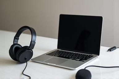 Laptop com fones de ouvido e microfone para gravação remota